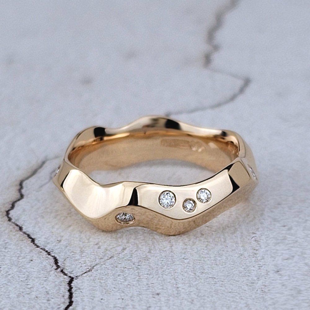 hand carved wedding ring in rose gold with scattered diamonds