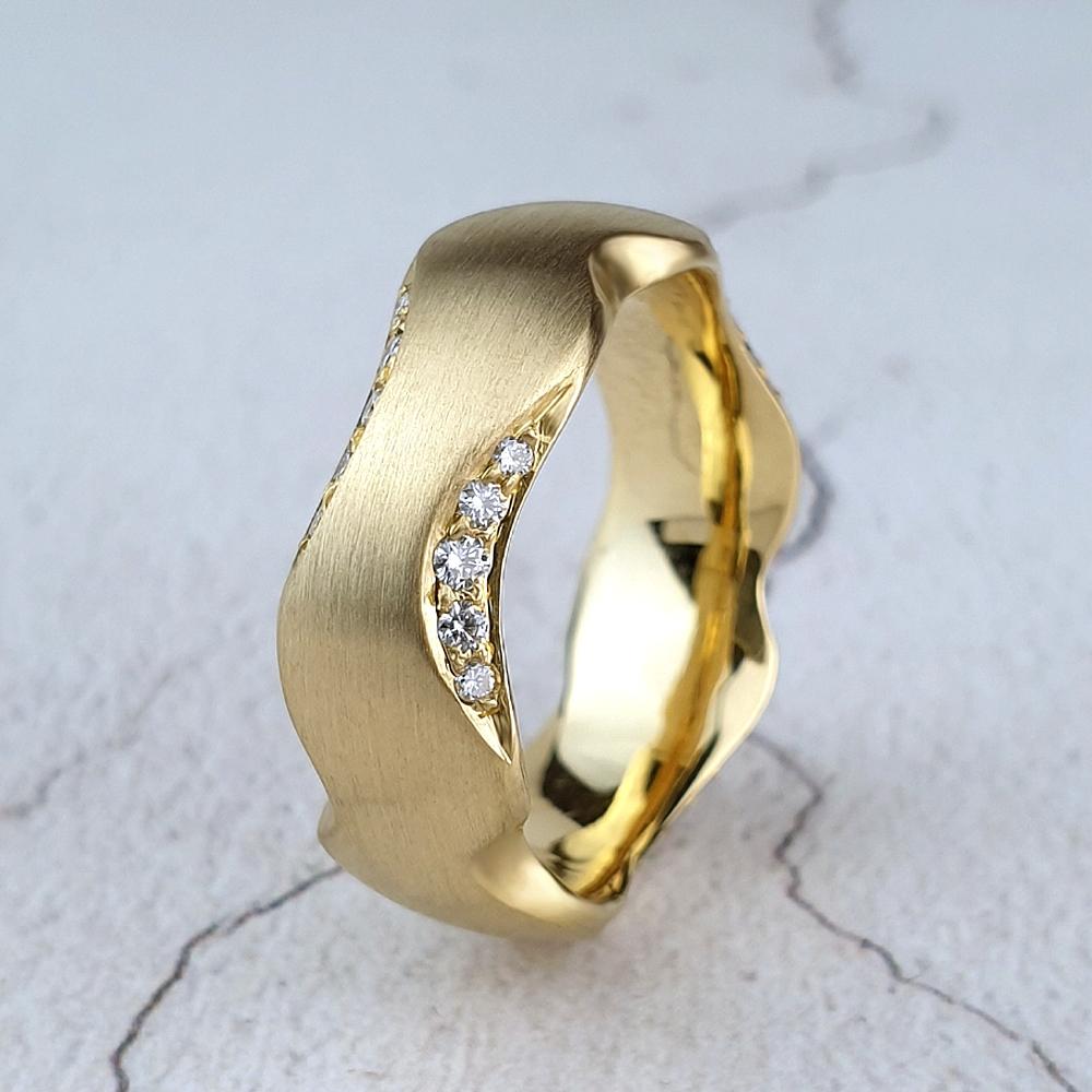 Carved gold band with chamfered sides set with diamonds
