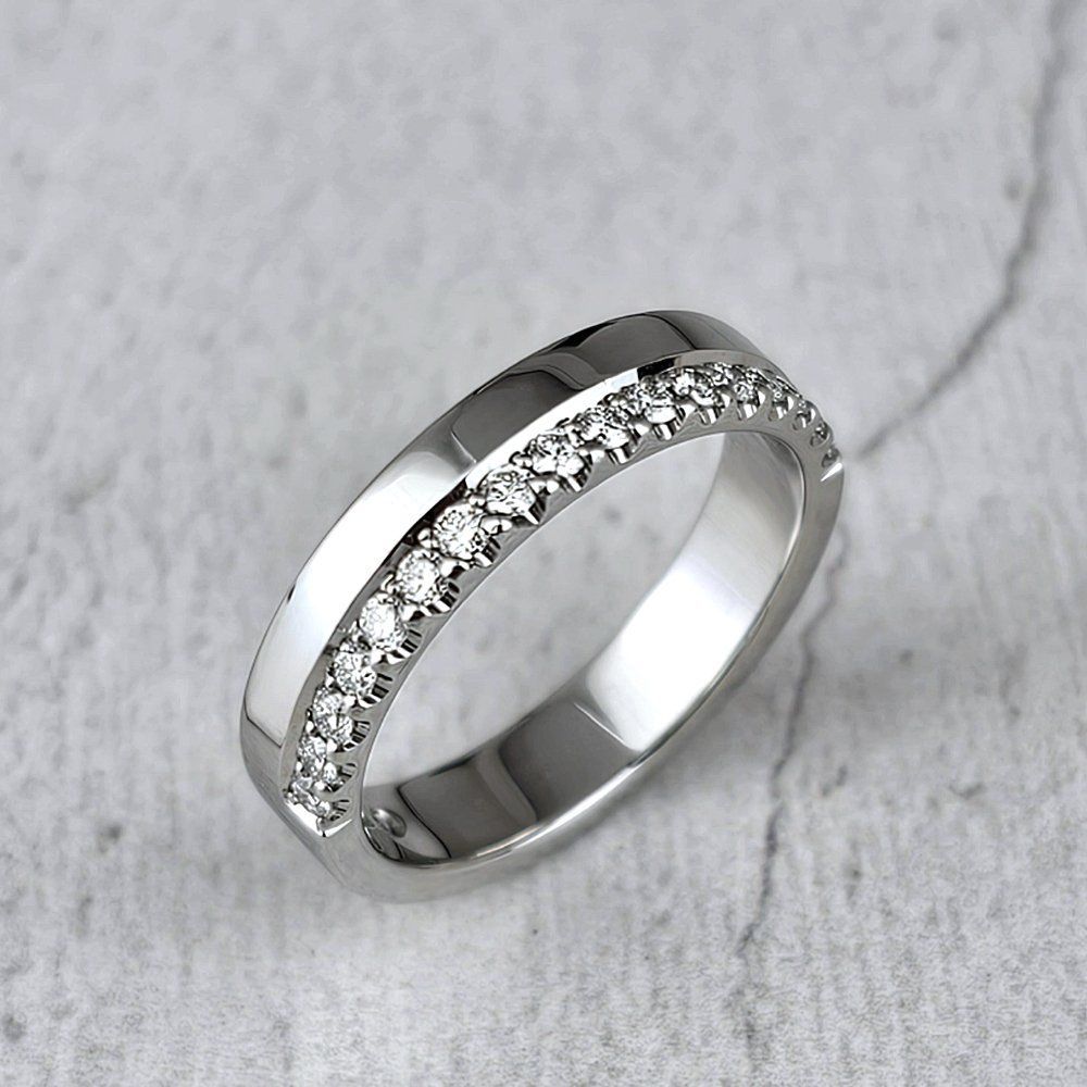 a platinum wedding ring with a row of diamonds castle-set along one side