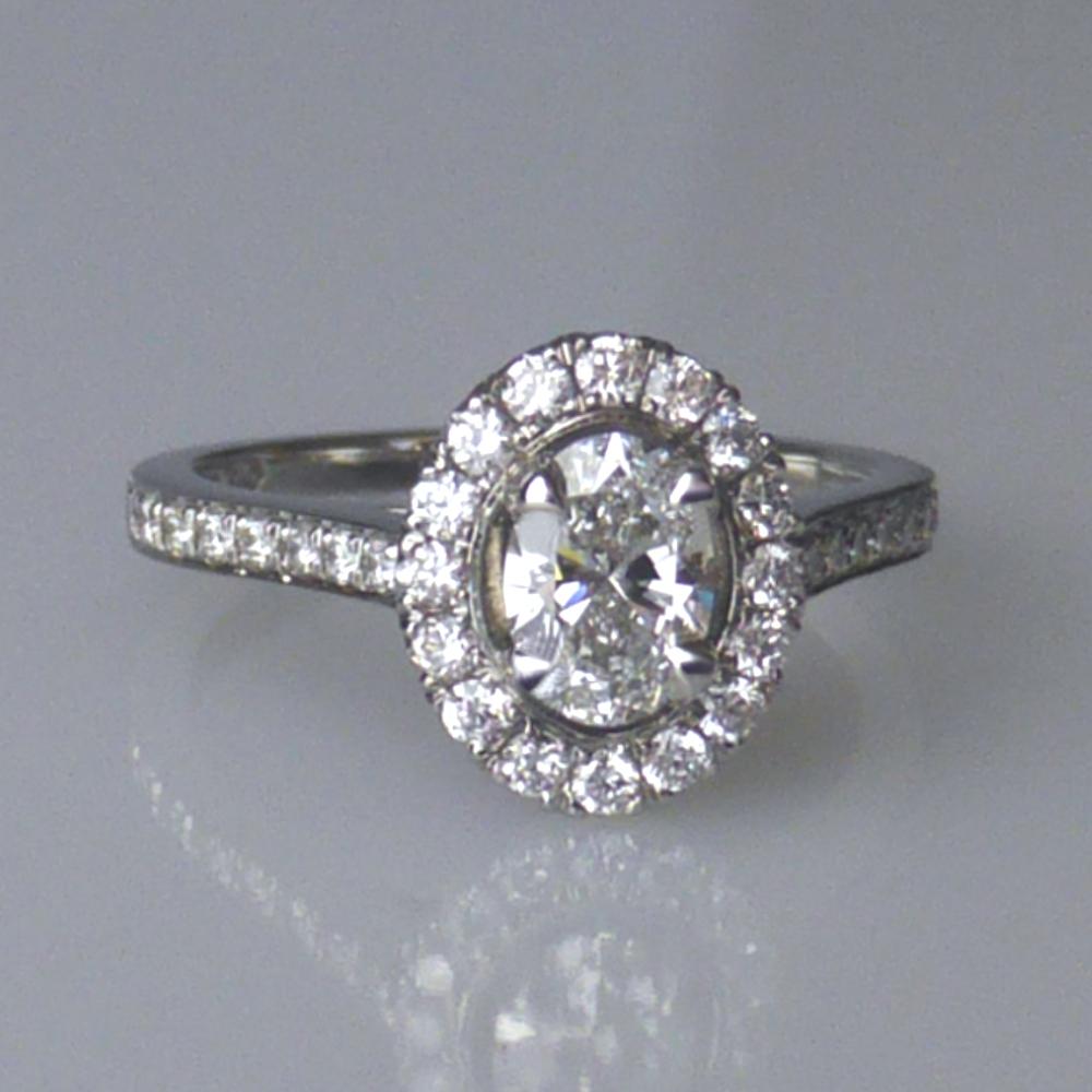 A halo engagement ring with an oval diamond
