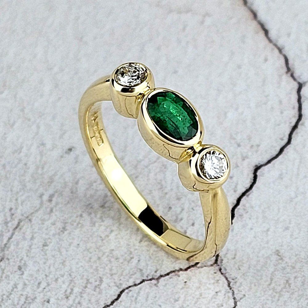 Three-stone emerald and diamond engagement ring