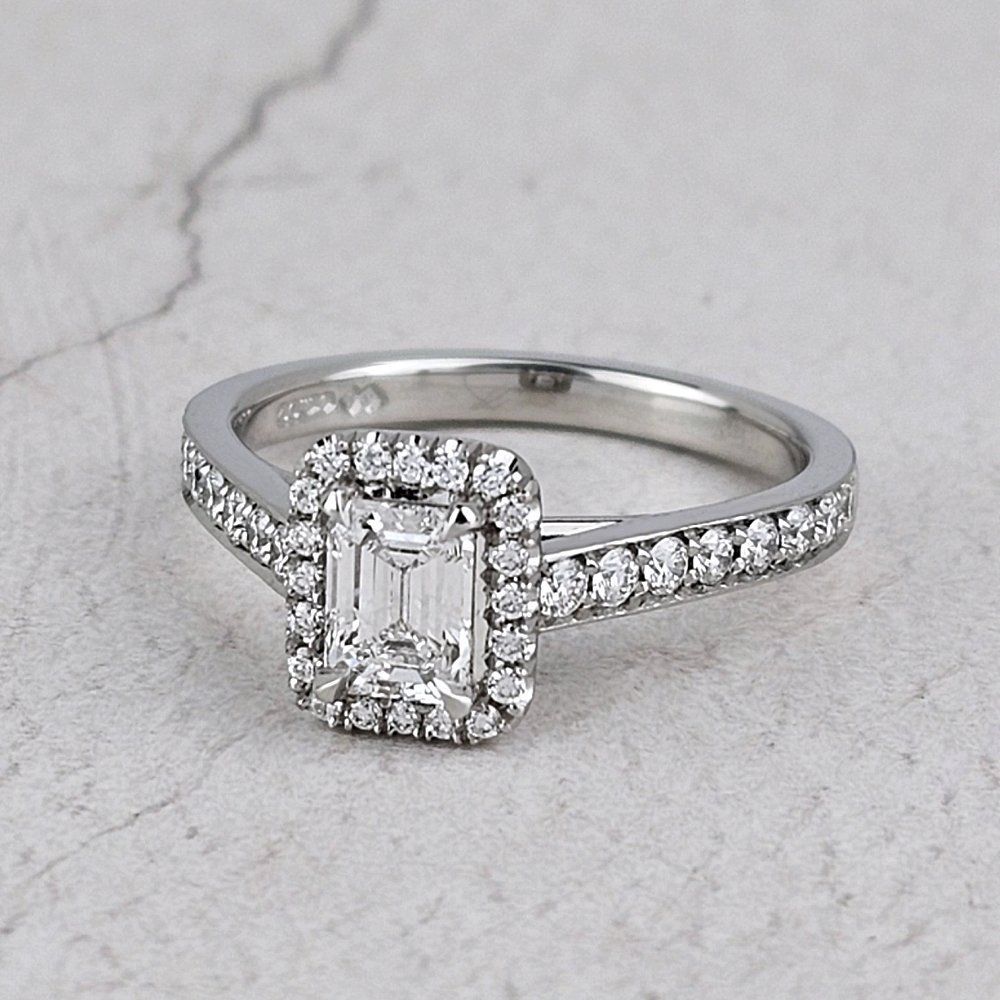 A halo engagement ring with an emerald-cut diamond