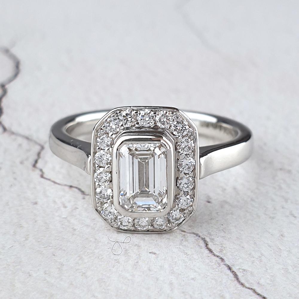 A bespoke halo engagement ring with an emerald-cut diamond