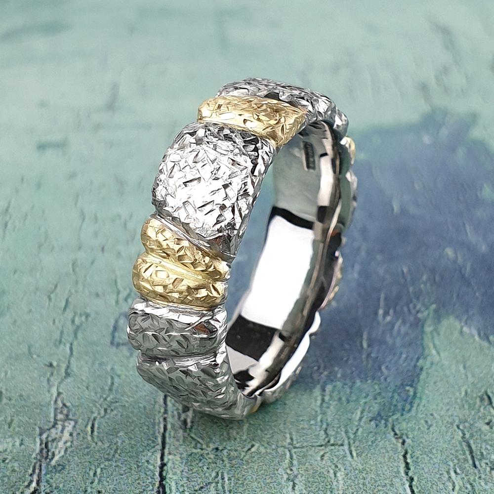 Gold wedding ring inlaid with platinum and textured.