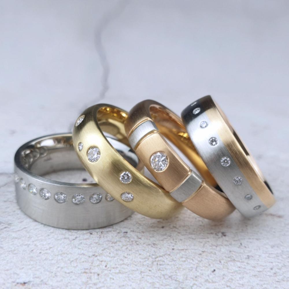Selection of men's wedding bands with gypsy-set diamonds