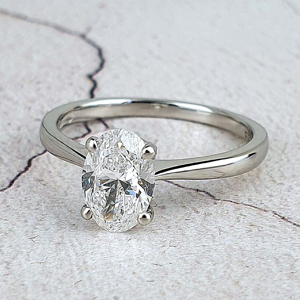 a platinum solitaire engagement ring with an oval diamond