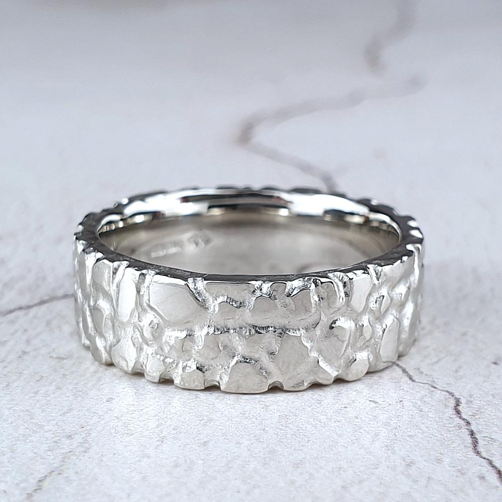 A wide platinum band with  a nugget texture