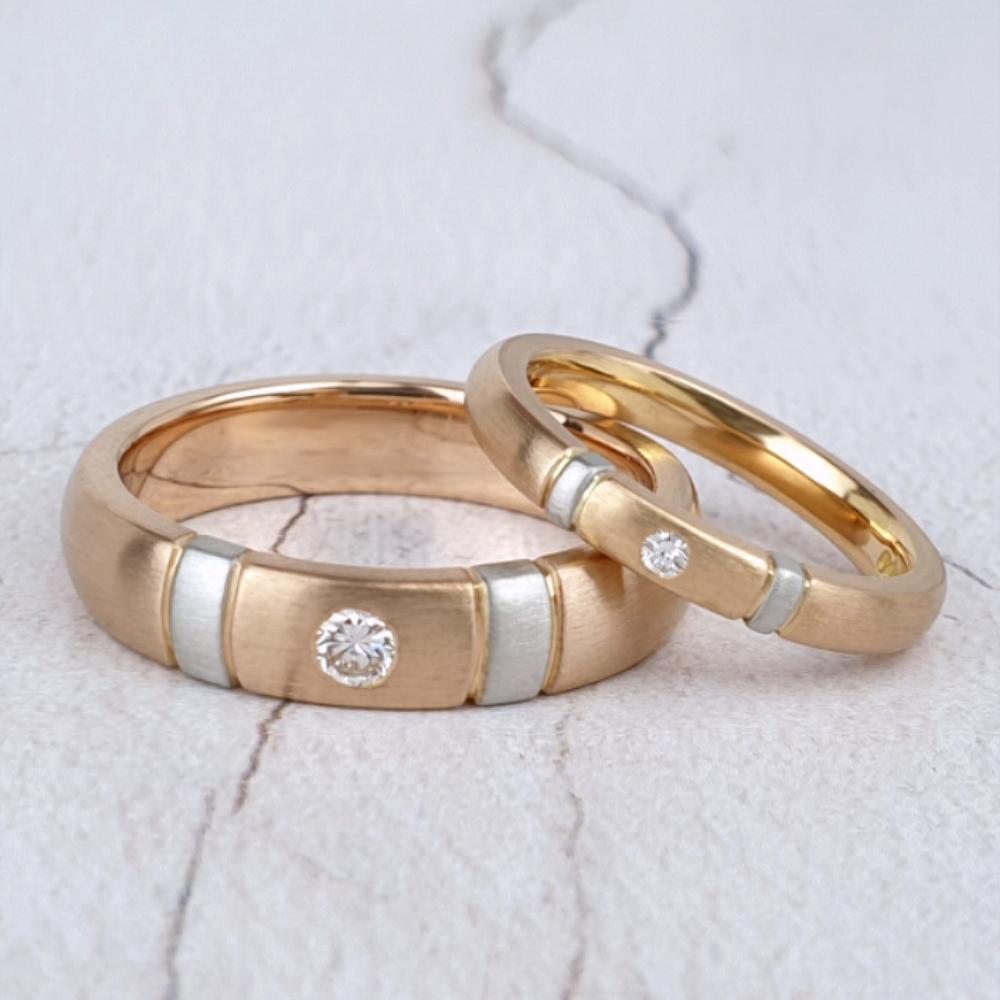 Red gold wedding rings with platinum stripes and single diamond