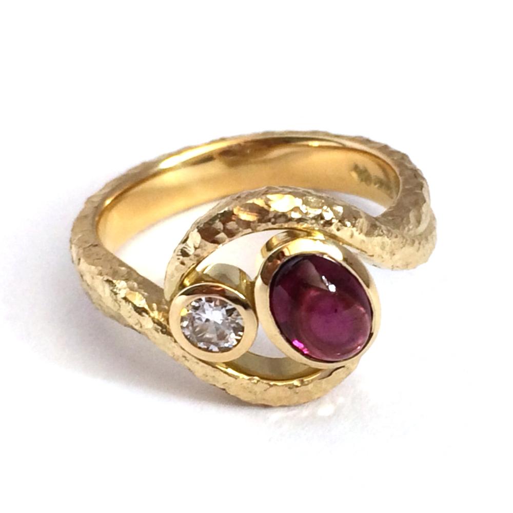 A bespoke dress ring with a cabochon rhodolite in yellow gold