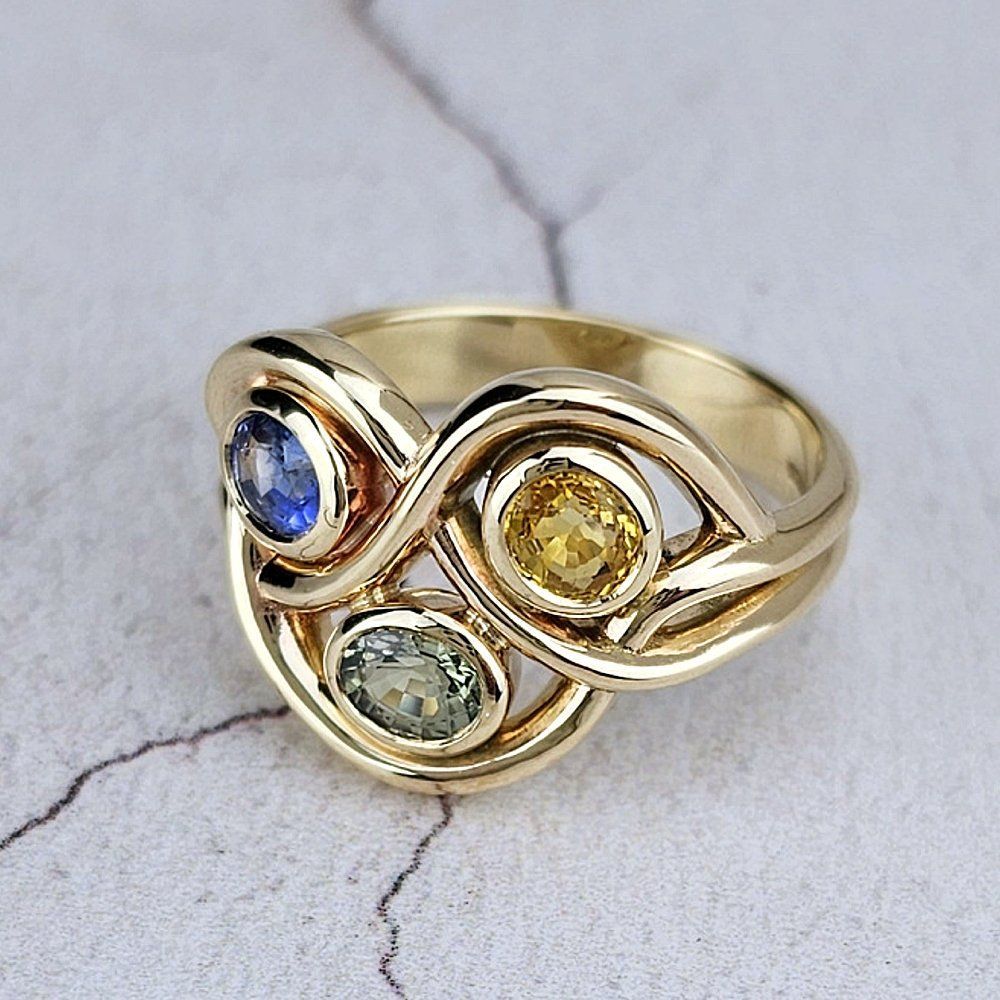 low gold ring with three different coloured sapphires