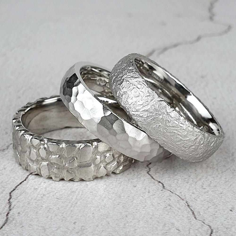 three men's wedding rings with different textures