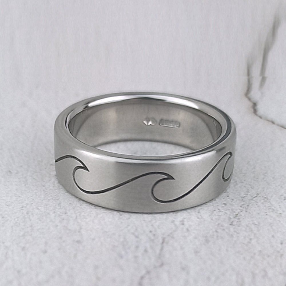 plain matte platinum wedding ring with simple laser-engraved wave.