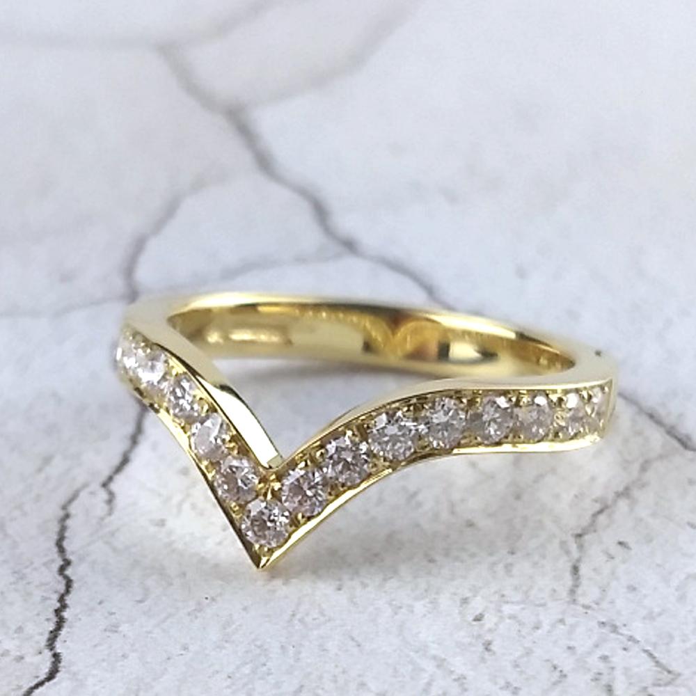 Yellow gold wishbone ring with pavé-set diamonds.