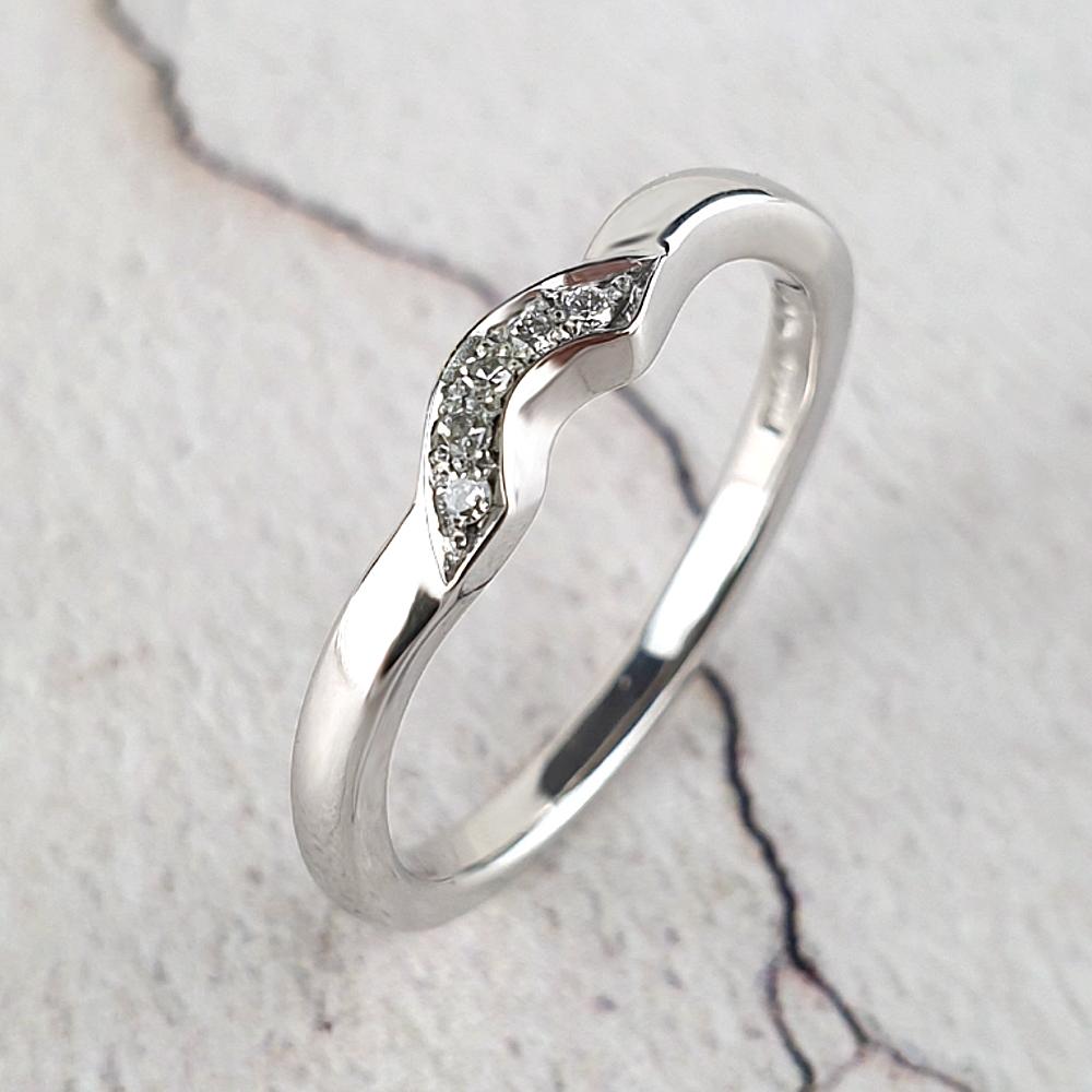 A dainty fitted wedding ring with an arc of small diamonds