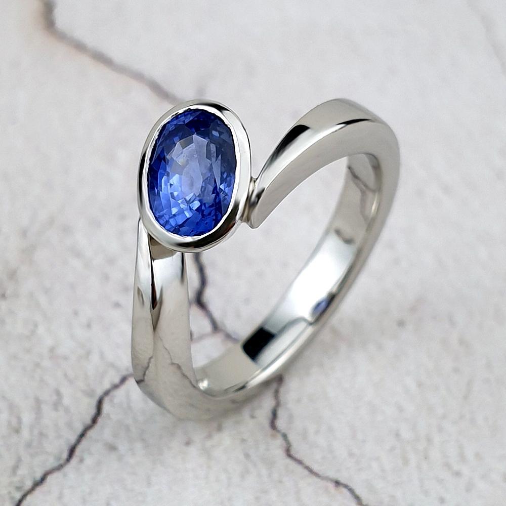 Platinum Flick engagement ring with an oval blue sapphire.