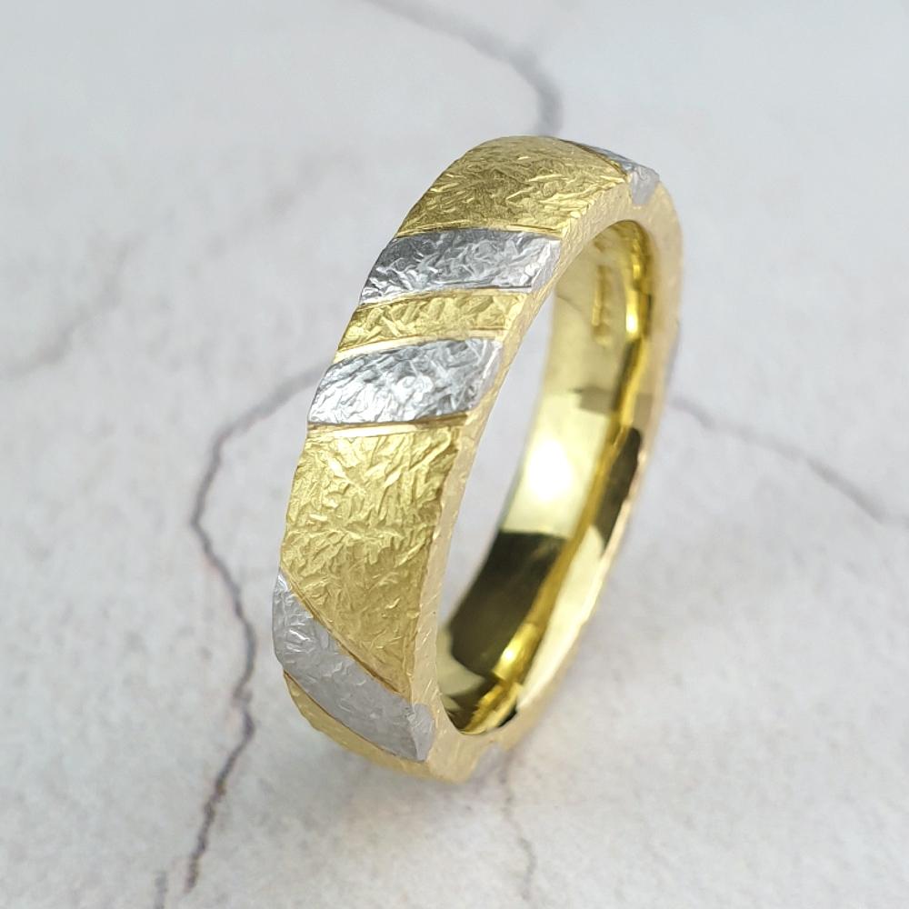 Gold wedding ring inlaid with platinum and textured.