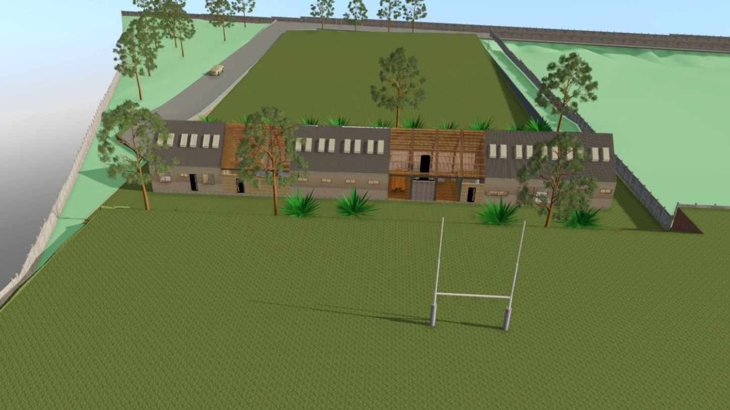 Representación 3D de un edificio con una portería de rugby en un campo verde. Se ven árboles y una carretera.