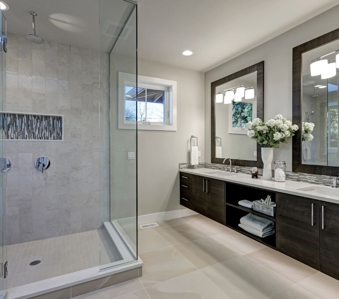 Modern bathroom with a glass shower, double vanity, and neutral color palette.