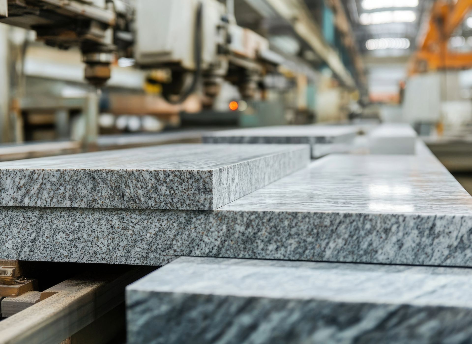 Granite slabs in a factory setting, awaiting processing by machinery.