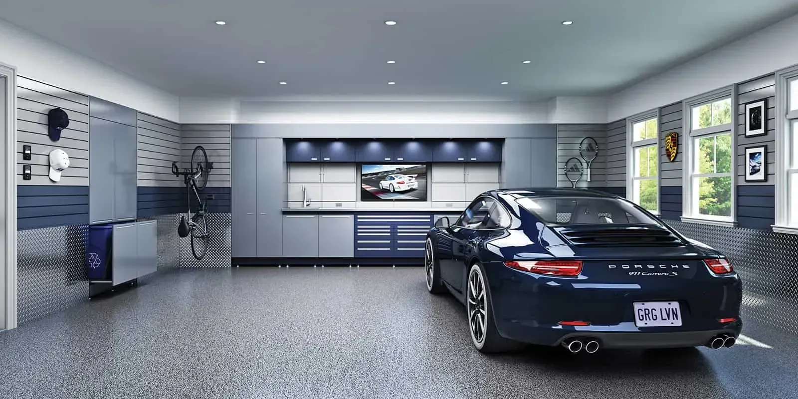 A luxury garage with a blue Porsche parked inside. The space features modern cabinets, a TV, and a speckled floor.