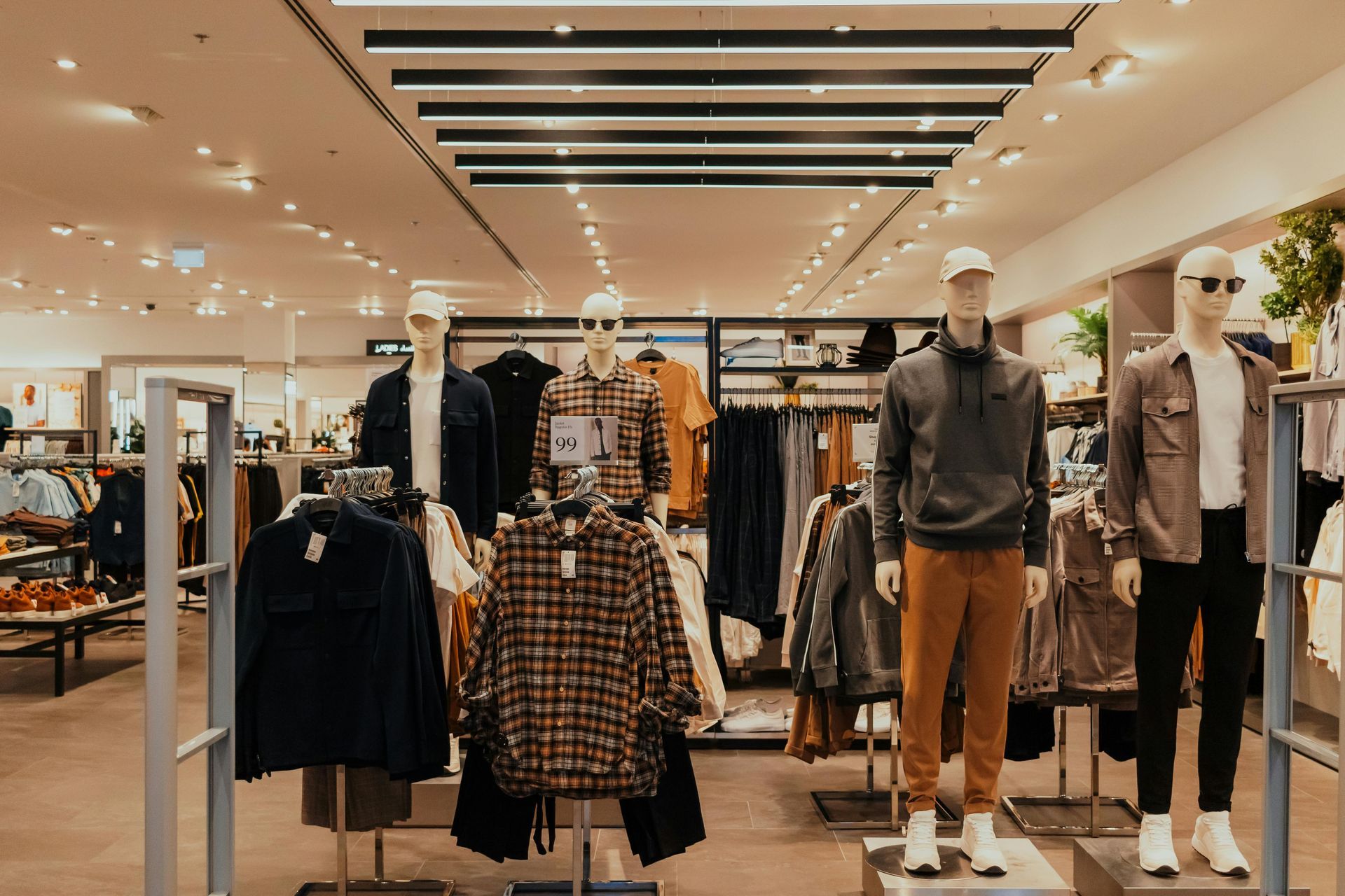 Clothing store interior, mannequins wearing fall clothing.
