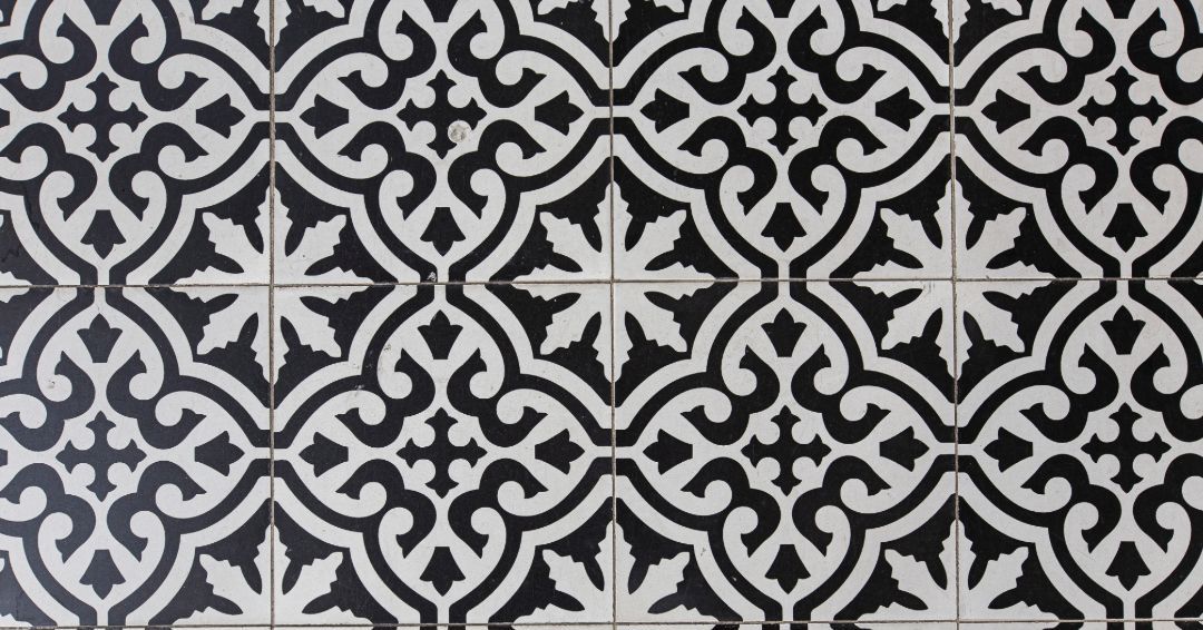Black and white patterned tiles with a floral and scroll design.