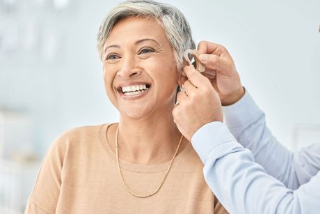 Senior patient, hearing aid and doctor hands, ear and listening, help and trust, healthcare and medicine. Medical tech, consultation with ENT specialist and health, happy woman and people at clinic
