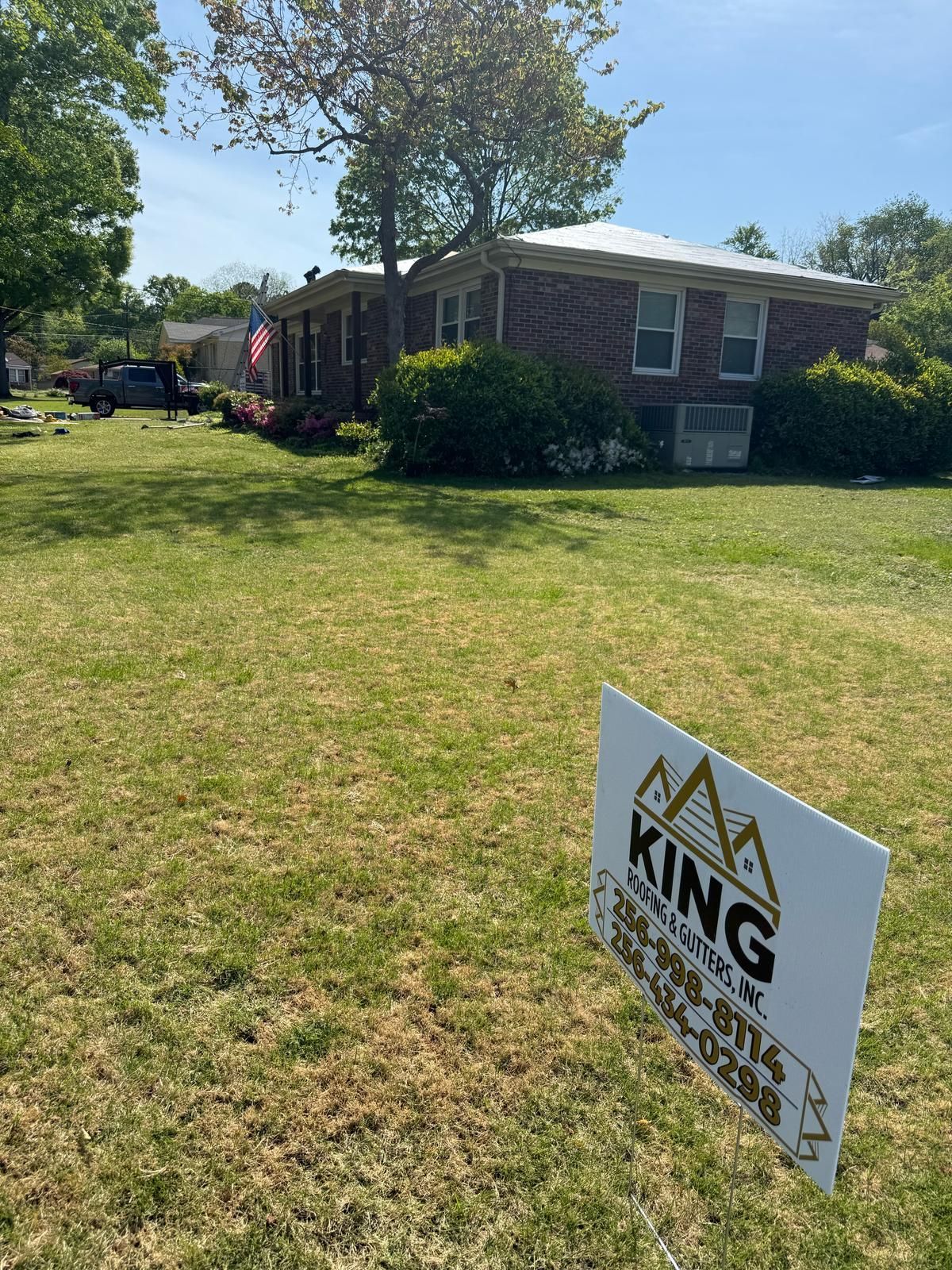 A single-story brick house with a lawn and a 