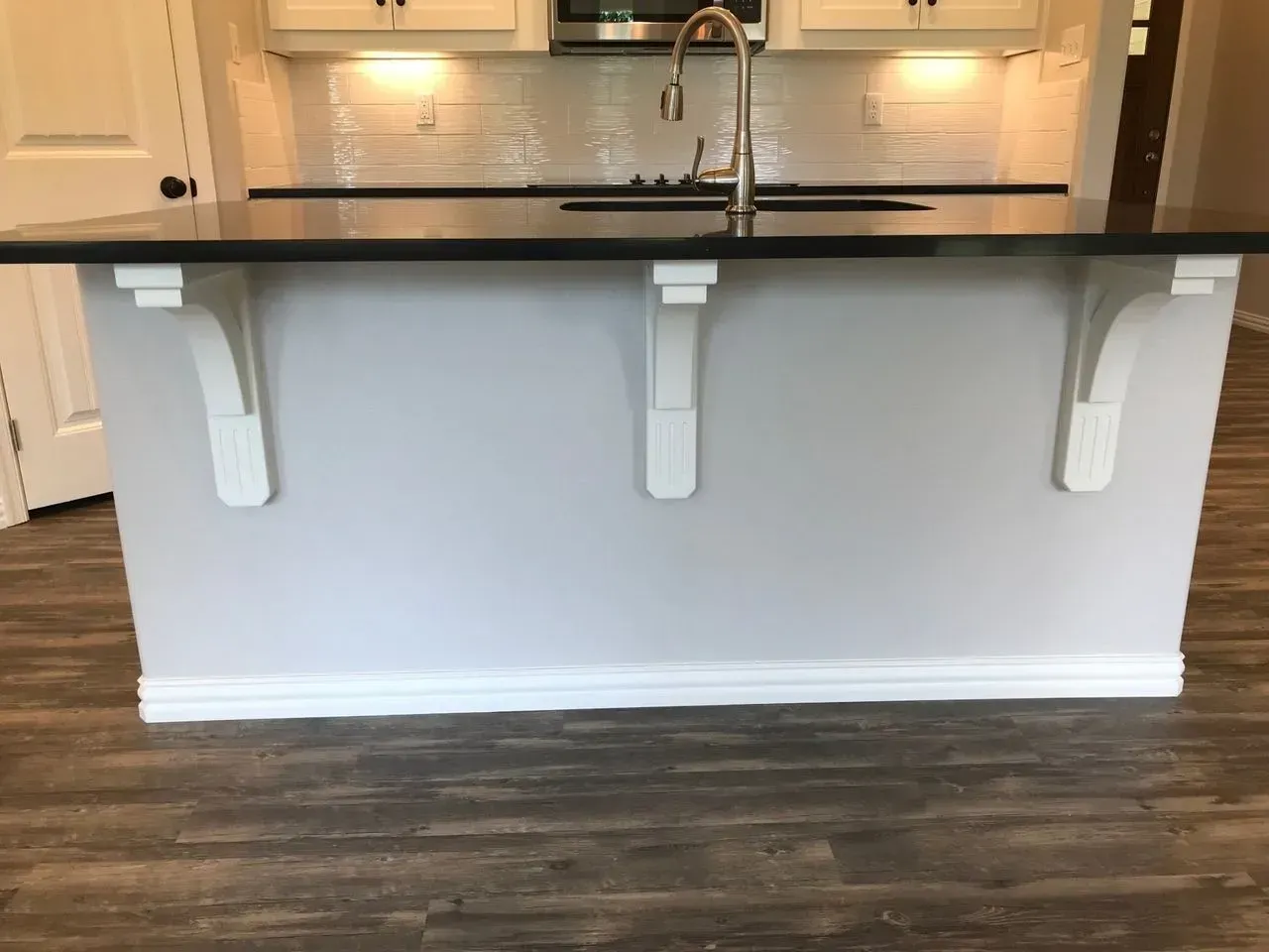 A kitchen with a large island and a sink.