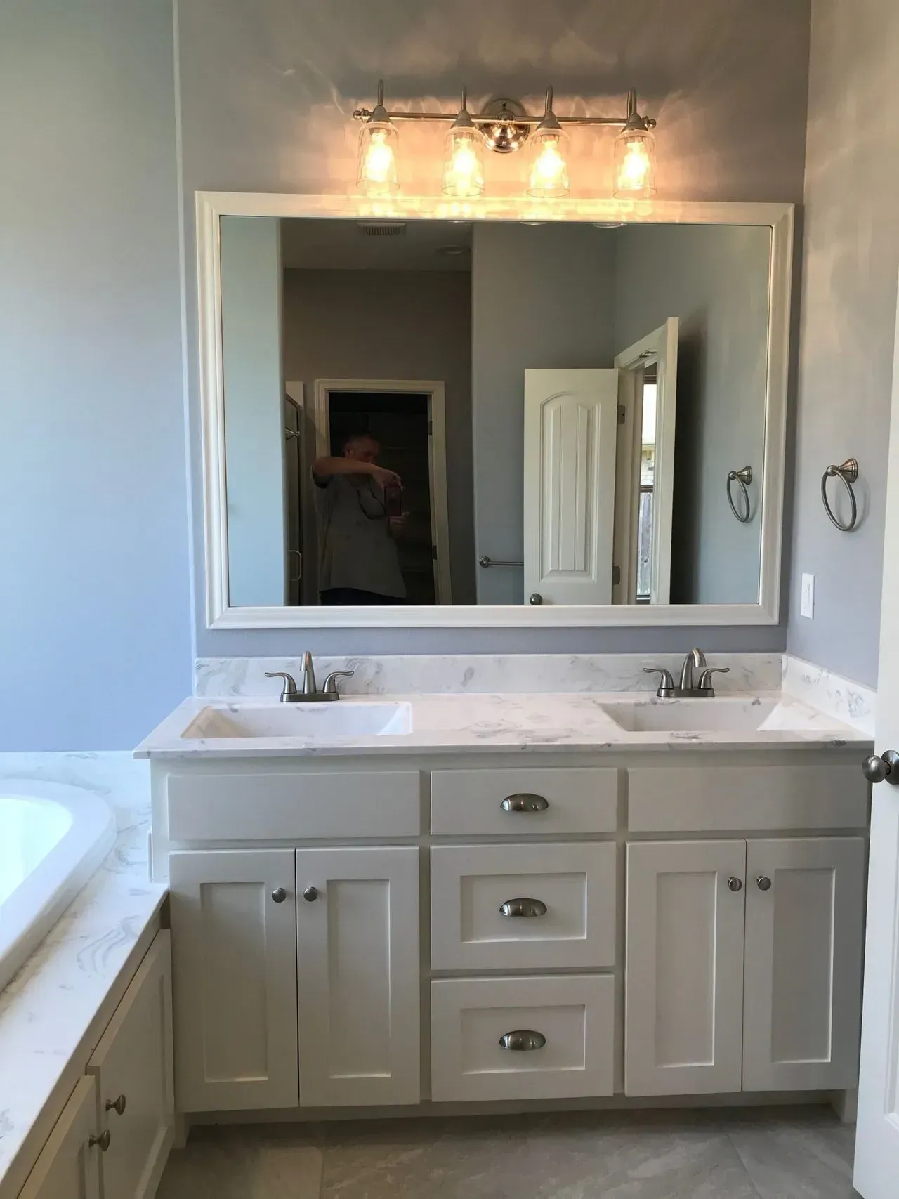 A bathroom with two sinks and a large mirror