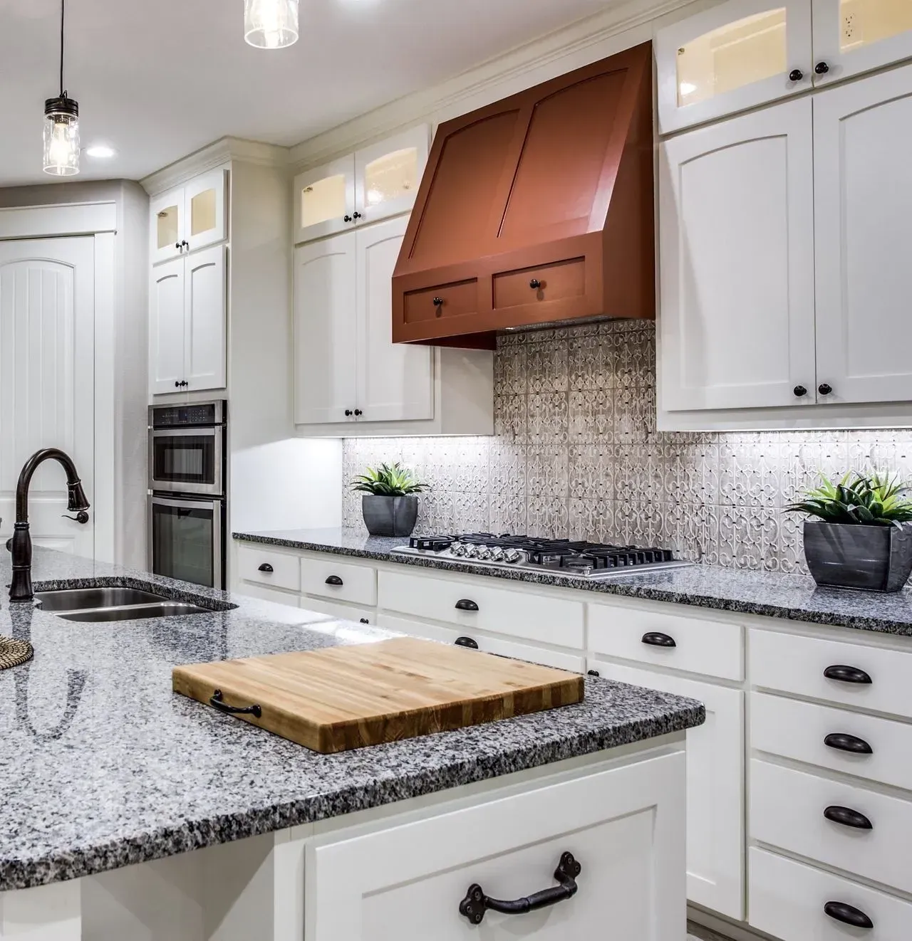 A kitchen with white cabinets and granite counter tops