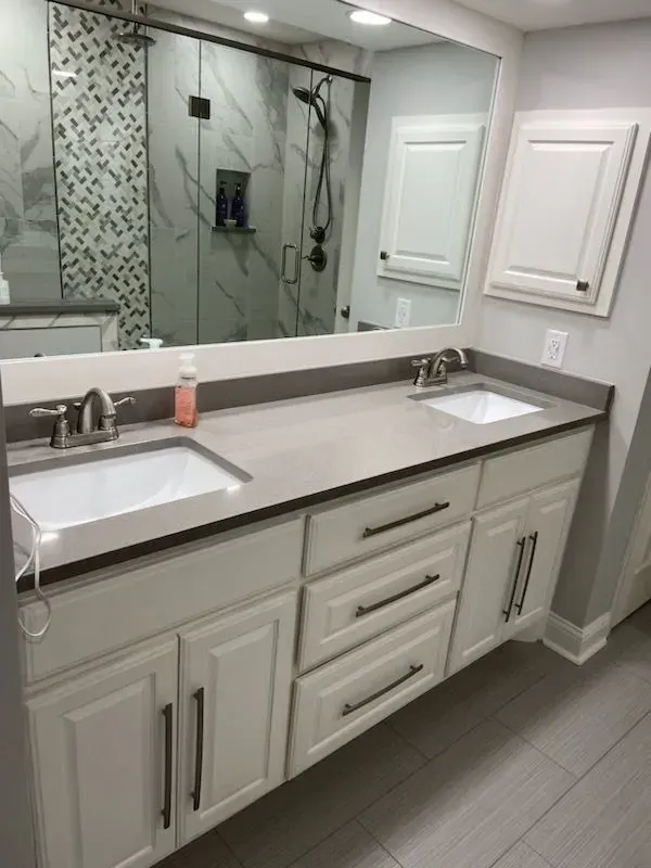 A bathroom with two sinks and a large mirror