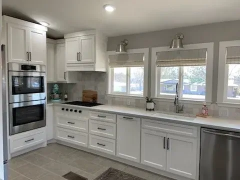 A kitchen with white cabinets and stainless steel appliances.