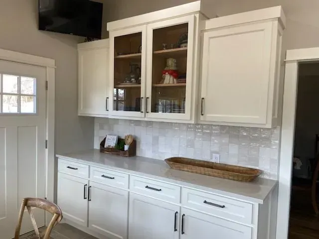 A kitchen with white cabinets and white counter tops