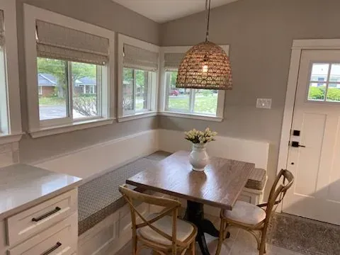 There is a table and chairs in the corner of the room.