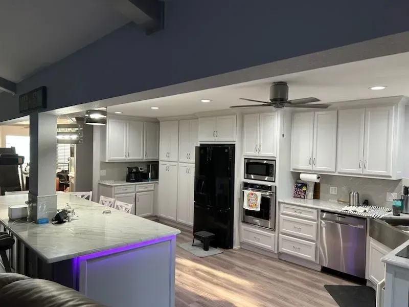 A kitchen with white cabinets and stainless steel appliances.