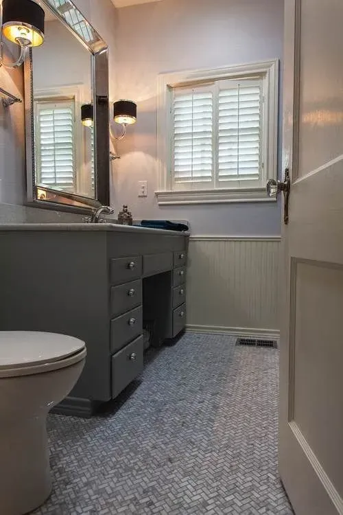 A bathroom with a toilet a sink and a mirror