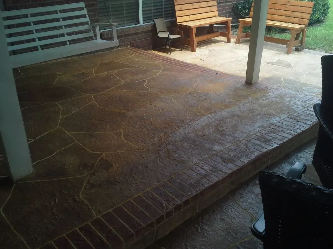 A patio with a bench and chairs on it