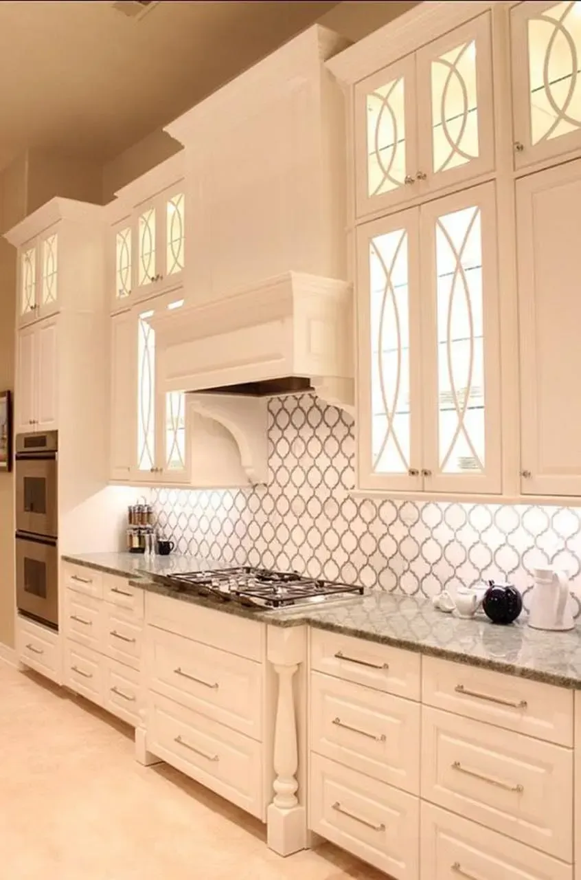 A kitchen with white cabinets and a stove top oven