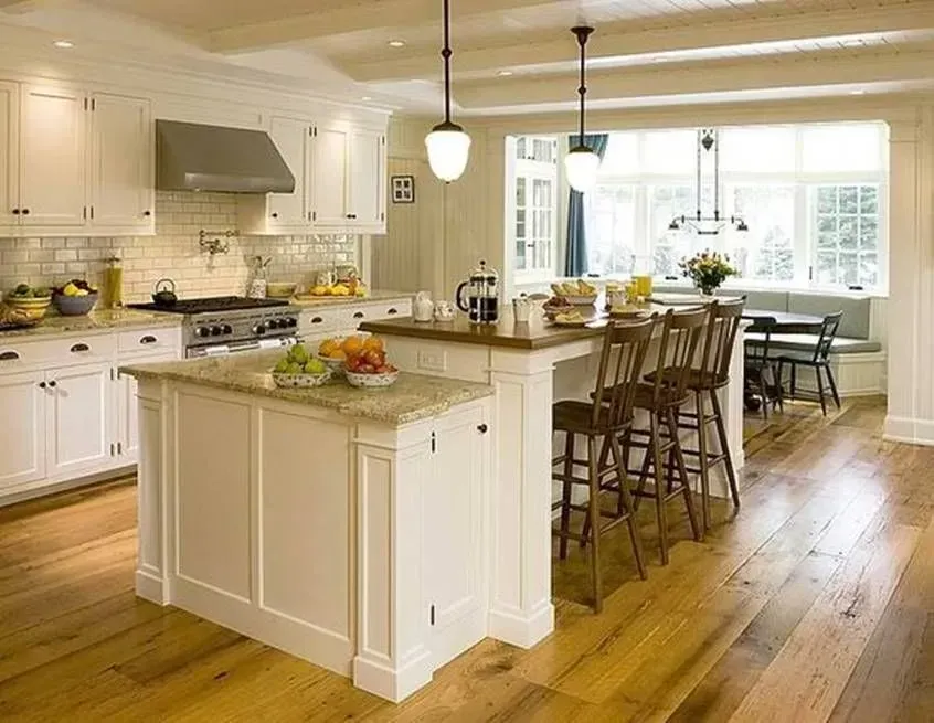 A kitchen with white cabinets and a large island in the middle