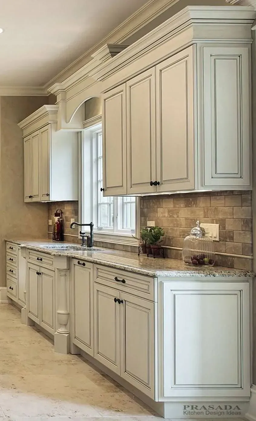 A kitchen with white cabinets , granite counter tops , and a sink.