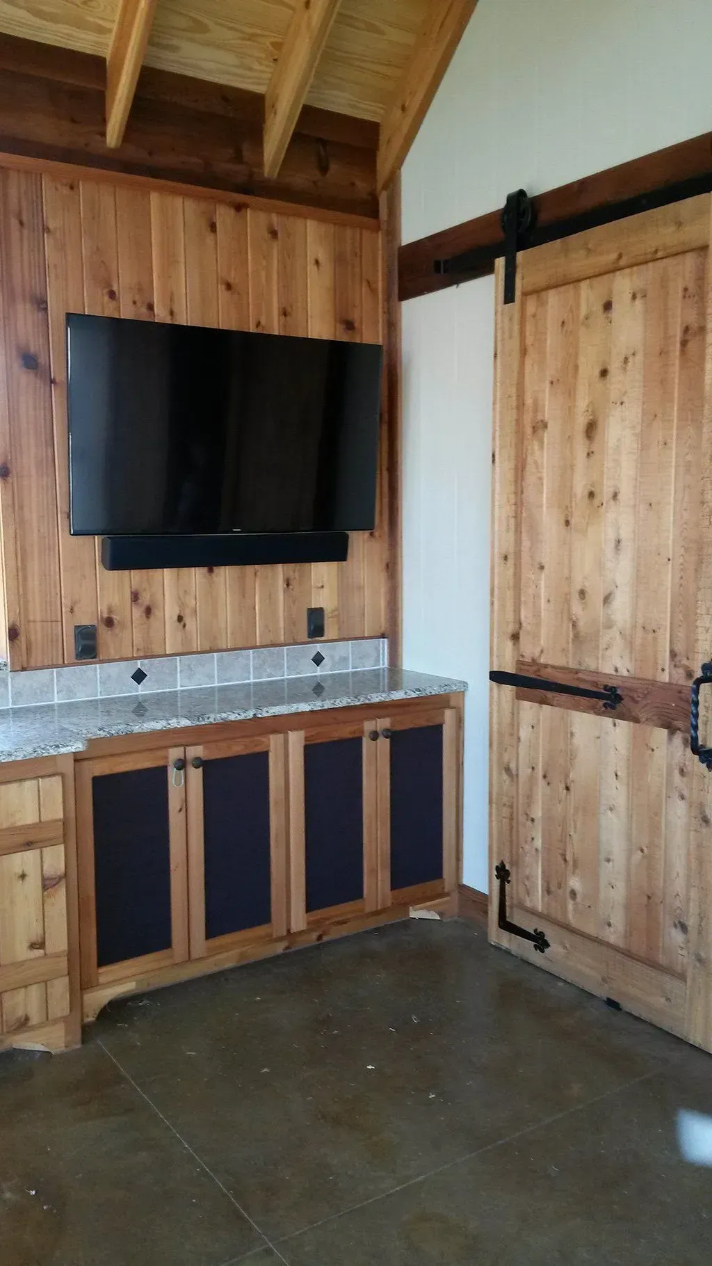 A kitchen with a flat screen tv mounted on the wall.