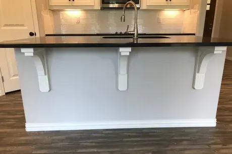 A kitchen with a large island and a sink.