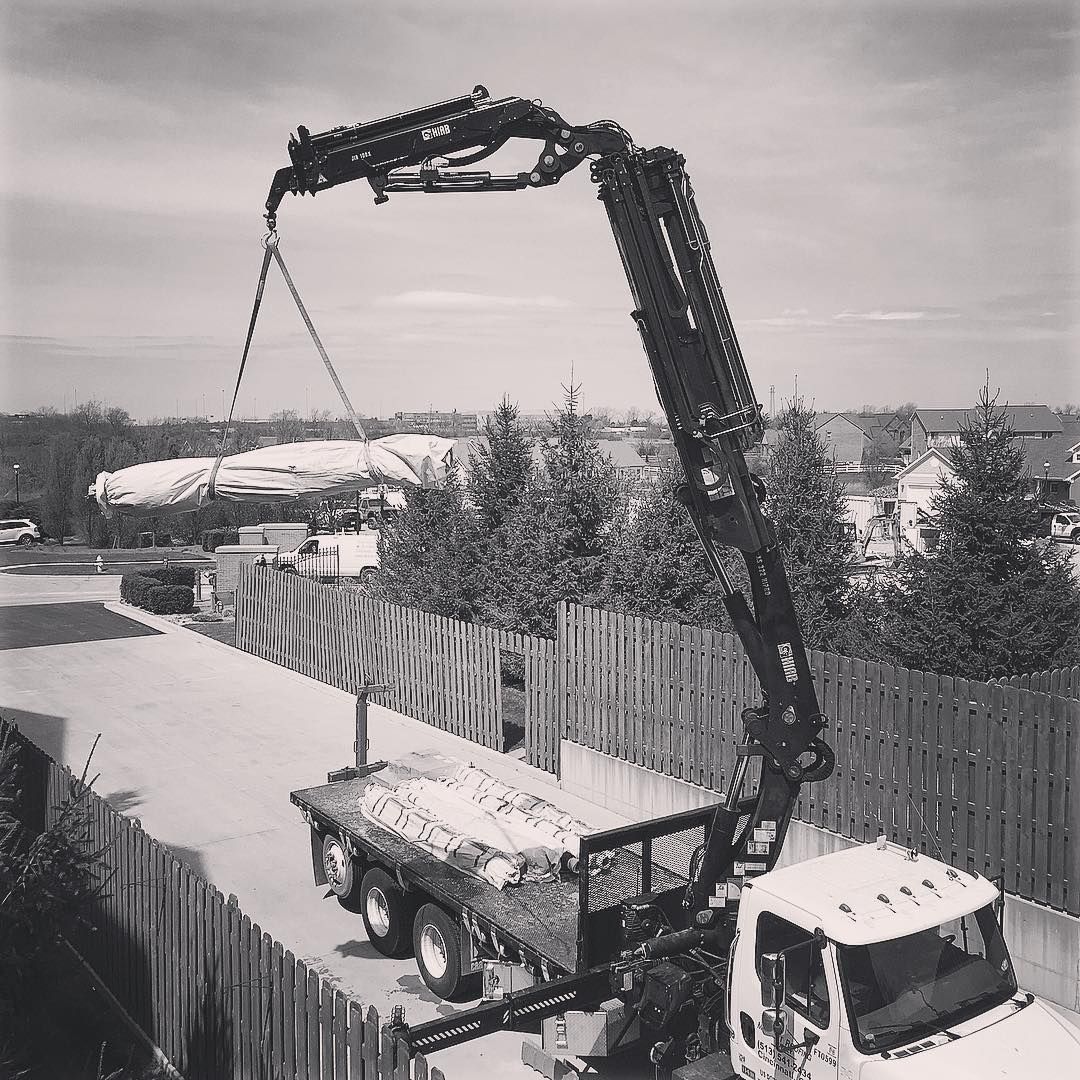 A black and white photo of a truck with a crane attached to it