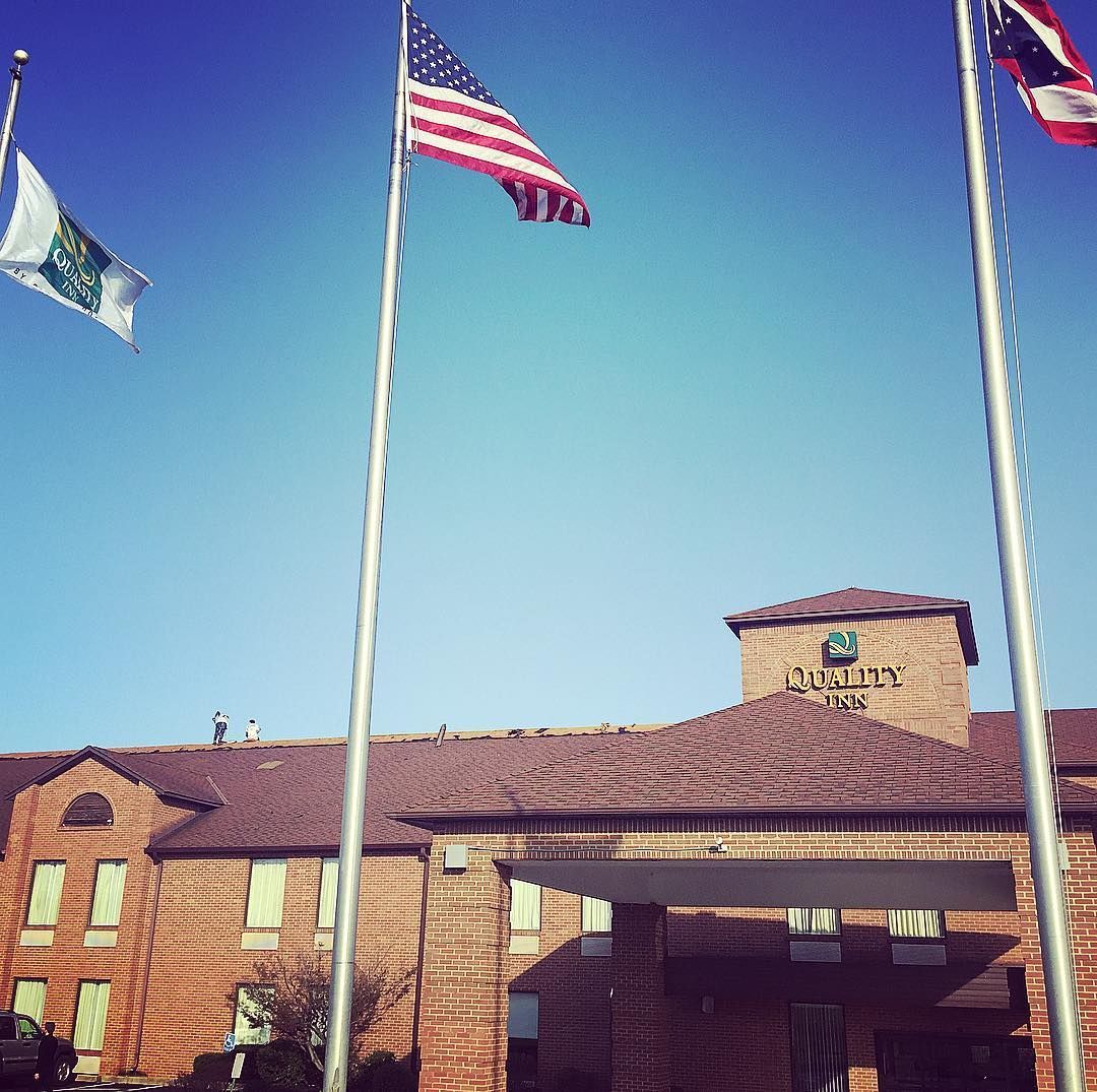 An american flag is flying in front of a brick building