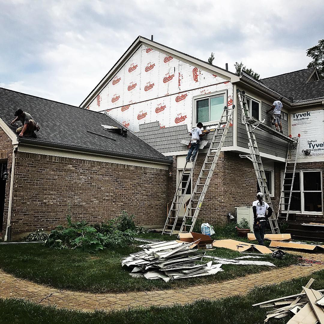 A group of men are working on the roof of a house.