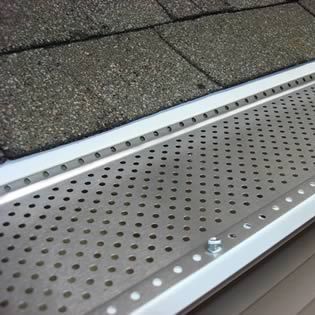 A gutter with holes in it is sitting on top of a roof.