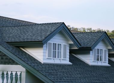 The roof of a house with two windows on it