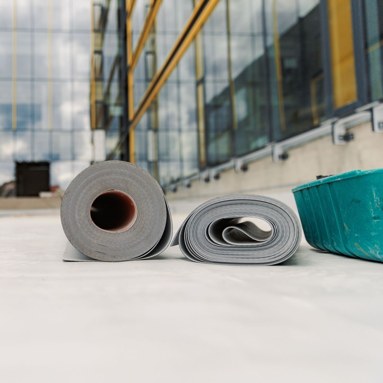 Two rolls of toilet paper are laying on the ground in front of a building.