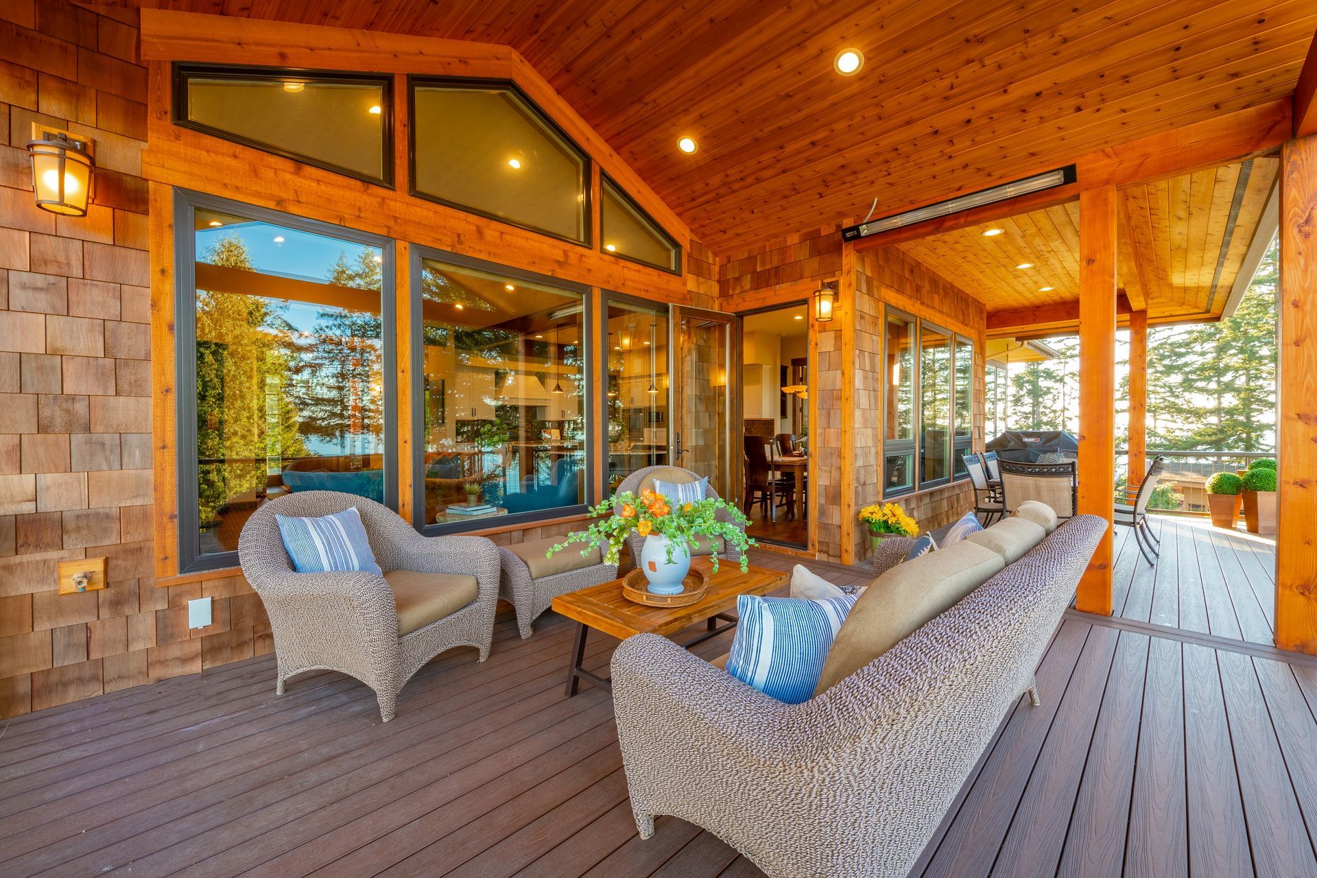 A large porch with a couch , chairs , and a table.